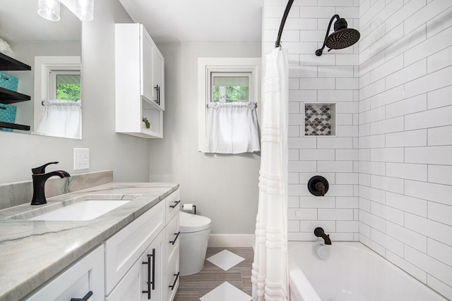 2016 Engleside Dr SE, Grand Rapids, MI 49546 - full bathroom featuring vanity, toilet, shower / bath combo with shower curtain, baseboards, and wood finished floors