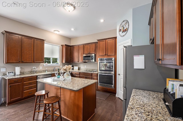 825 Mcintosh Ct, Oakland, MI 48363 - kitchen featuring appliances with stainless steel finishes, a kitchen island, dark wood-style floors, light stone countertops, and recessed lighting