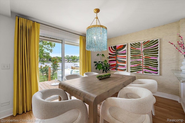 600 Wolverine Dr, Walled Lake, MI 48390 - dining space featuring baseboards, a chandelier, light wood-style flooring, and a water view