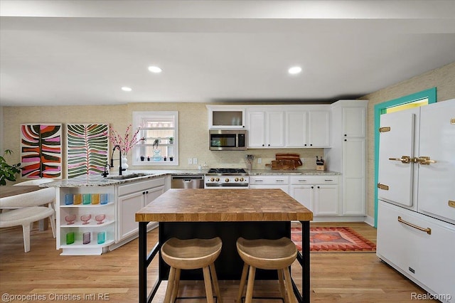 600 Wolverine Dr, Walled Lake, MI 48390 - kitchen featuring appliances with stainless steel finishes, a sink, wooden counters, a kitchen breakfast bar, and recessed lighting