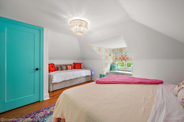 600 Wolverine Dr, Walled Lake, MI 48390 - bedroom with vaulted ceiling, wood finished floors, and a chandelier