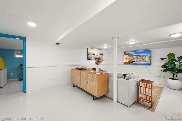 600 Wolverine Dr, Walled Lake, MI 48390 - living area with concrete flooring and a wainscoted wall