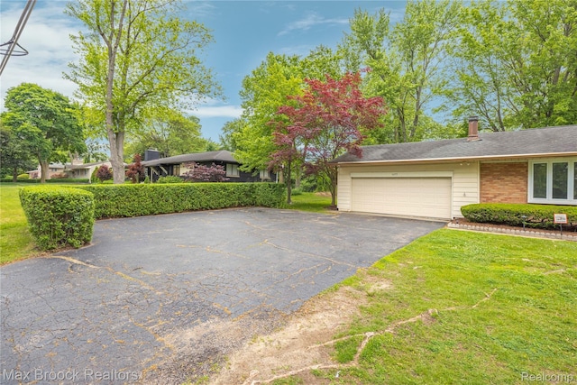 6695 Lahser Rd, Bloomfield Hills, MI 48301 - view of front of house with a garage, asphalt driveway, and a front lawn