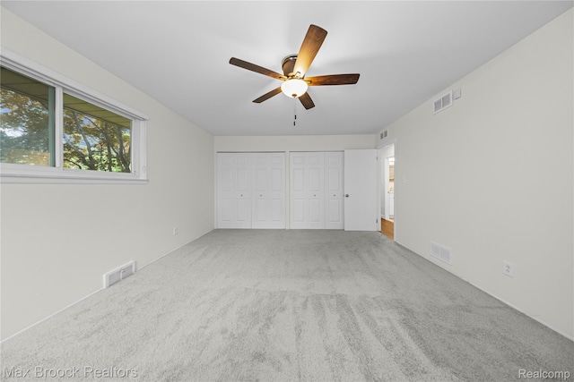 6695 Lahser Rd, Bloomfield Hills, MI 48301 - unfurnished bedroom featuring two closets, carpet floors, and a ceiling fan