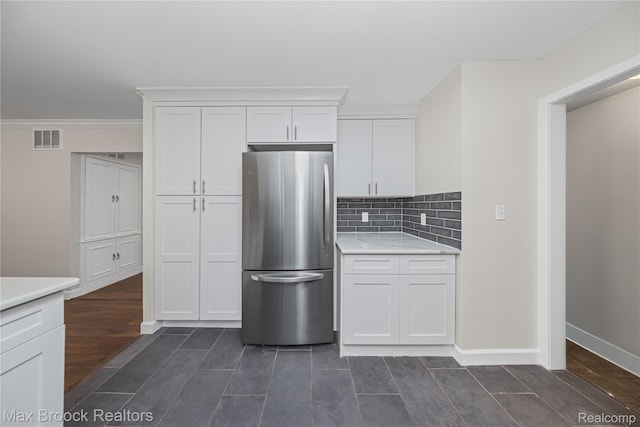 6695 Lahser Rd, Bloomfield Hills, MI 48301 - kitchen with freestanding refrigerator, white cabinetry, backsplash, wood finish floors, and crown molding