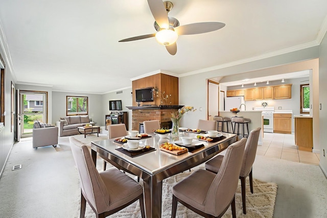 2800 Kimberley Rd, Ann Arbor, MI 48104 - dining space with crown molding, healthy amount of natural light, ceiling fan, a brick fireplace, and baseboards
