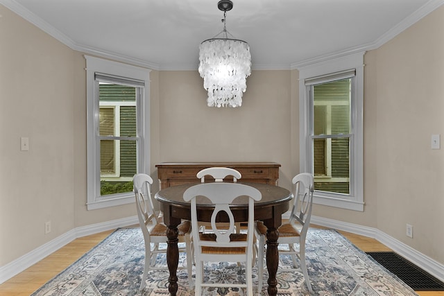 1118 Main St, Saint Joseph, MI 49085 - dining room featuring a chandelier, light wood-style flooring, ornamental molding, and baseboards