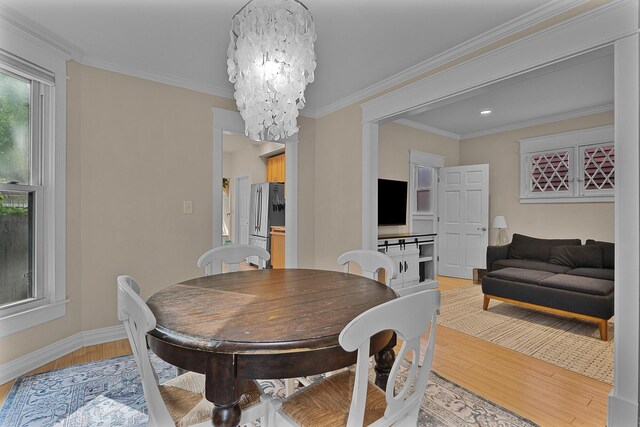 1118 Main St, Saint Joseph, MI 49085 - dining space with light wood-style flooring, a chandelier, baseboards, and ornamental molding