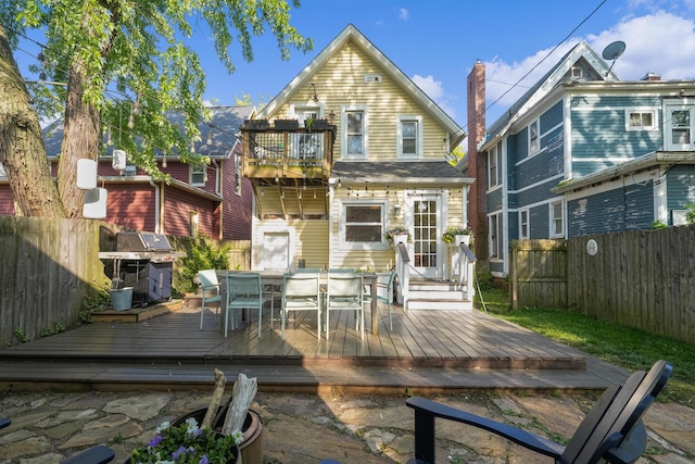 1118 Main St, Saint Joseph, MI 49085 - rear view of house featuring a fenced backyard, outdoor dining space, a balcony, and a deck