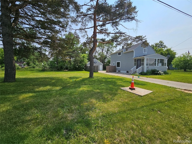 1073 W Bristol Rd, Grand Blanc, MI 48507 - view of grassy yard featuring a sunroom and a detached garage
