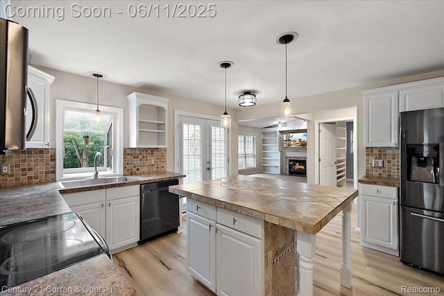 1134 Chestnut Ln, South Lyon, MI 48178 - kitchen with stainless steel refrigerator with ice dispenser, black dishwasher, tile countertops, a sink, and light wood-style floors