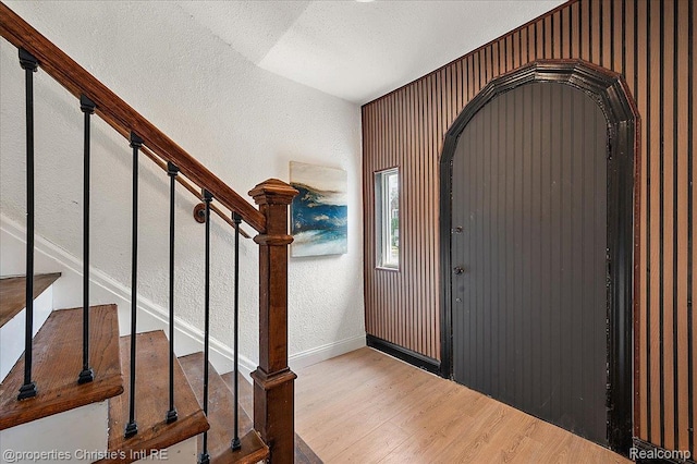 17155 Wisconsin St, Detroit, MI 48221 - entryway featuring wood finished floors, stairs, baseboards, a textured wall, and arched walkways
