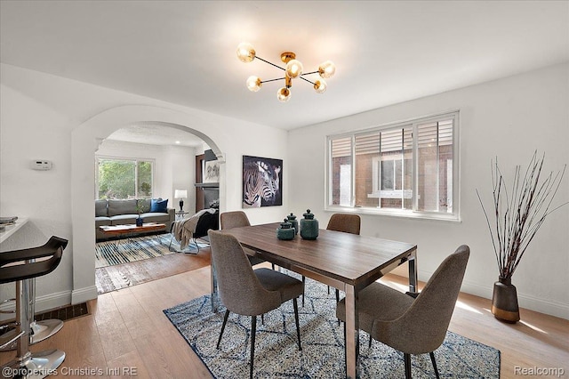 17155 Wisconsin St, Detroit, MI 48221 - dining room with arched walkways, baseboards, light wood finished floors, and a chandelier