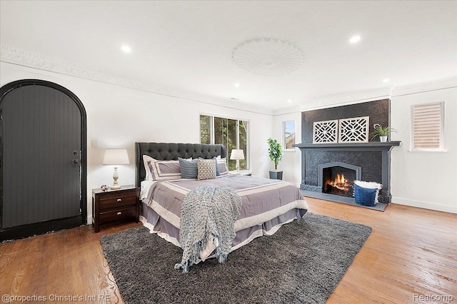 17155 Wisconsin St, Detroit, MI 48221 - bedroom featuring crown molding, wood finished floors, a large fireplace, recessed lighting, and baseboards