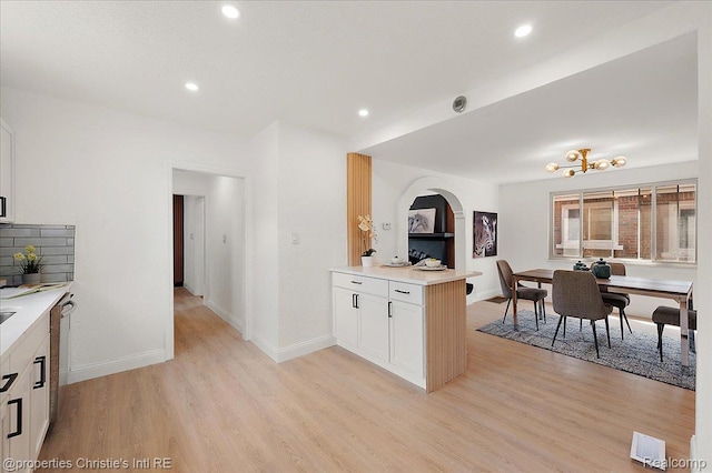 17155 Wisconsin St, Detroit, MI 48221 - kitchen with light wood-style flooring, light countertops, recessed lighting, white cabinets, and baseboards