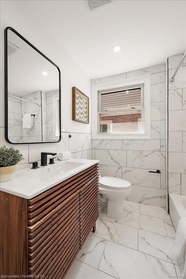 17155 Wisconsin St, Detroit, MI 48221 - bathroom with tile walls, vanity, toilet, marble finish flooring, and shower / tub combination