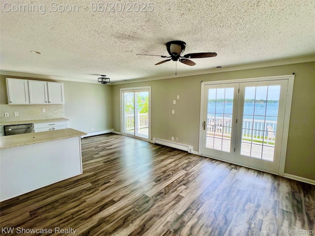 1869 Union Lake Rd, Commerce Twp, MI 48382 - unfurnished living room featuring a baseboard heating unit, a baseboard radiator, a ceiling fan, dark wood-type flooring, and a textured ceiling