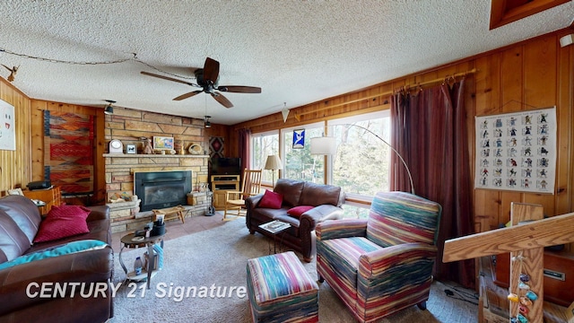 8285 Seymour Rd, Flushing, MI 48433 - carpeted living room featuring wood walls, ceiling fan, a fireplace, and a textured ceiling