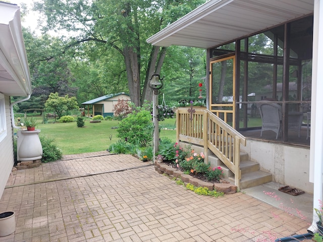 70170 Ironwood Dr, Niles, MI 49120 - view of patio featuring a sunroom, view of wooded area, and an outbuilding