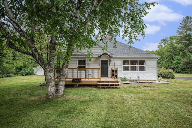 455 N 10th St, Plainwell, MI 49080 - view of front facade with a wooden deck, a chimney, a front lawn, and roof with shingles