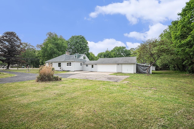 455 N 10th St, Plainwell, MI 49080 - back of house featuring a lawn, driveway, and a chimney