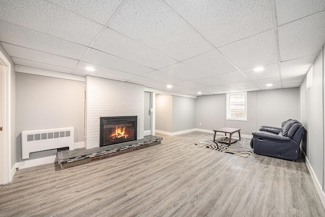 455 N 10th St, Plainwell, MI 49080 - sitting room with radiator, wood finished floors, baseboards, a paneled ceiling, and a fireplace