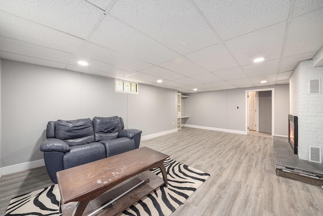 455 N 10th St, Plainwell, MI 49080 - living room with wood finished floors, baseboards, a drop ceiling, recessed lighting, and a brick fireplace