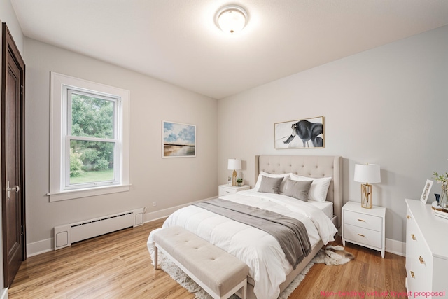 455 N 10th St, Plainwell, MI 49080 - bedroom with baseboard heating, light wood-style flooring, and baseboards