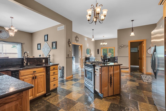7910 Stony Lake Rd, Jackson, MI 49201 - kitchen with a chandelier, a sink, stone tile flooring, appliances with stainless steel finishes, and dark countertops