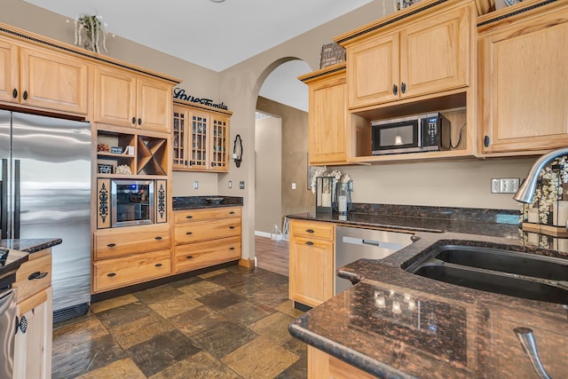 7910 Stony Lake Rd, Jackson, MI 49201 - kitchen featuring appliances with stainless steel finishes, light brown cabinetry, a sink, and arched walkways