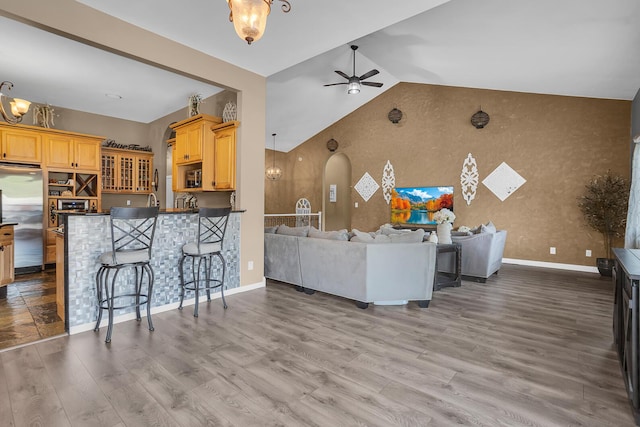 7910 Stony Lake Rd, Jackson, MI 49201 - living area featuring ceiling fan, arched walkways, lofted ceiling, wood finished floors, and baseboards