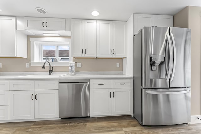 3551 W W Lake Mitchell Dr, Cadillac, MI 49601 - kitchen with appliances with stainless steel finishes, a sink, white cabinets, and light countertops