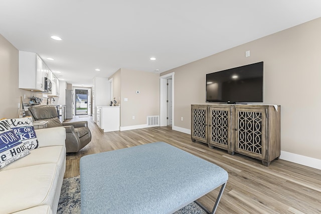 3551 W W Lake Mitchell Dr, Cadillac, MI 49601 - living room featuring light wood-style floors, baseboards, and recessed lighting