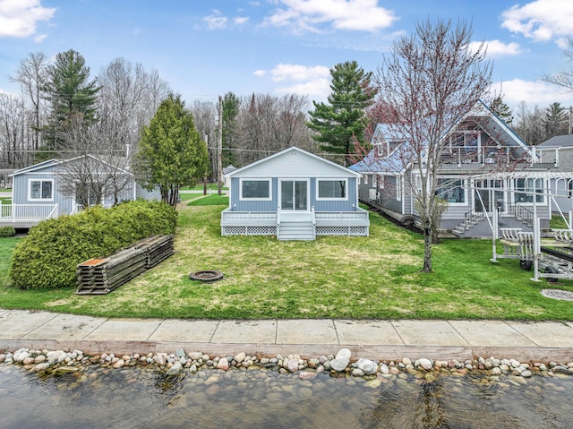 3551 W W Lake Mitchell Dr, Cadillac, MI 49601 - view of front of property featuring a fire pit, a deck with water view, and a front lawn