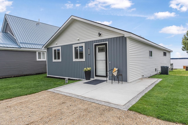 3551 W W Lake Mitchell Dr, Cadillac, MI 49601 - back of house featuring central AC unit, a lawn, and a patio