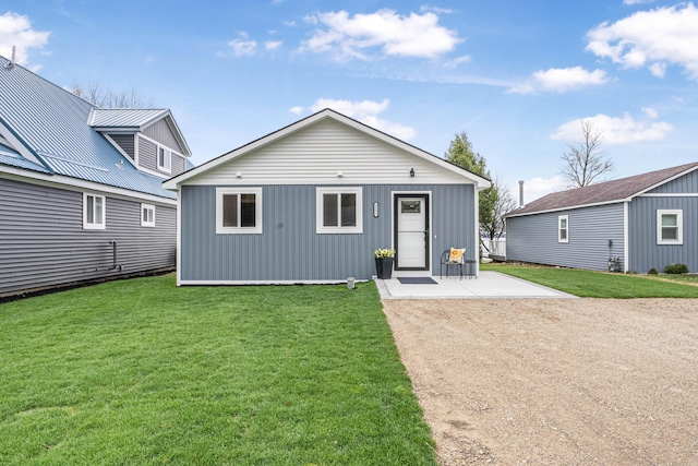 3551 W W Lake Mitchell Dr, Cadillac, MI 49601 - back of property with a lawn, a patio area, and metal roof