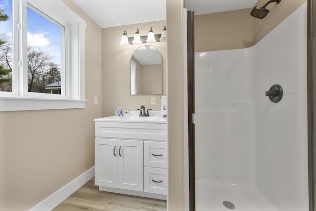 3551 W W Lake Mitchell Dr, Cadillac, MI 49601 - full bathroom with a stall shower, baseboards, vanity, and wood finished floors