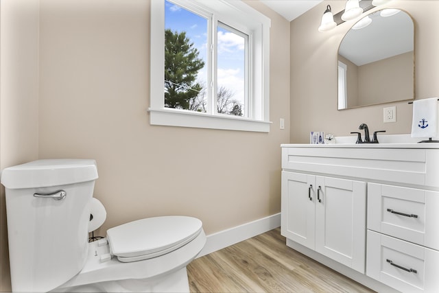 3551 W W Lake Mitchell Dr, Cadillac, MI 49601 - bathroom featuring toilet, vanity, baseboards, and wood finished floors