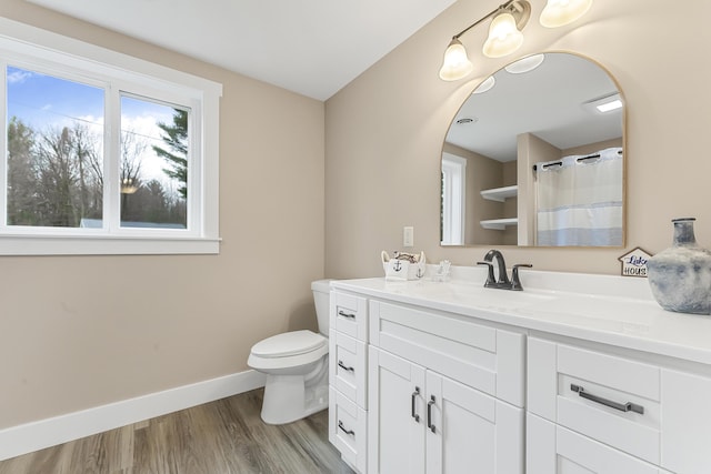 3551 W W Lake Mitchell Dr, Cadillac, MI 49601 - bathroom with toilet, vanity, baseboards, and wood finished floors