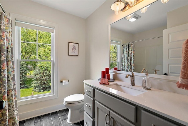 2582 3 Mile Rd NE, Grand Rapids, MI 49525 - full bath with vanity, wood finished floors, toilet, baseboards, and curtained shower
