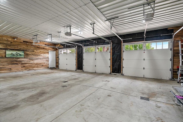 2582 3 Mile Rd NE, Grand Rapids, MI 49525 - garage featuring a garage door opener and wooden walls