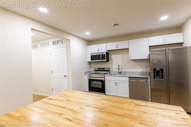 50824 Baltimore St, New Baltimore, MI 48047 - kitchen with appliances with stainless steel finishes, a sink, wood finished floors, white cabinetry, and recessed lighting