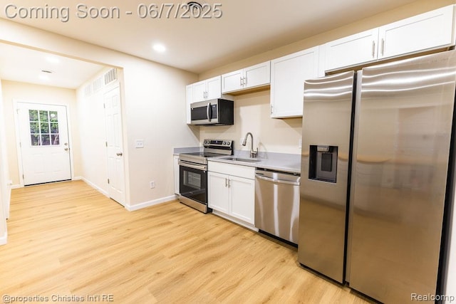 50824 Baltimore St, New Baltimore, MI 48047 - kitchen with appliances with stainless steel finishes, a sink, light wood finished floors, white cabinetry, and baseboards