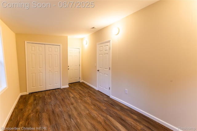 50824 Baltimore St, New Baltimore, MI 48047 - unfurnished bedroom with dark wood-type flooring, baseboards, and a closet