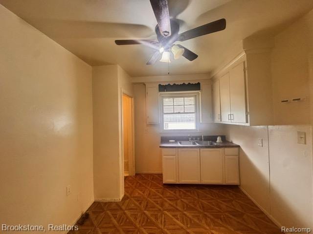 20951 Nummer St, Warren, MI 48089 - kitchen with a ceiling fan, a sink, white cabinetry, baseboards, and dark countertops