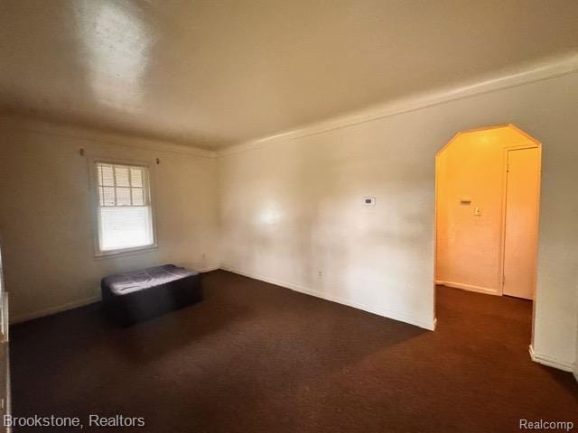 20951 Nummer St, Warren, MI 48089 - unfurnished room with arched walkways, dark colored carpet, crown molding, and baseboards