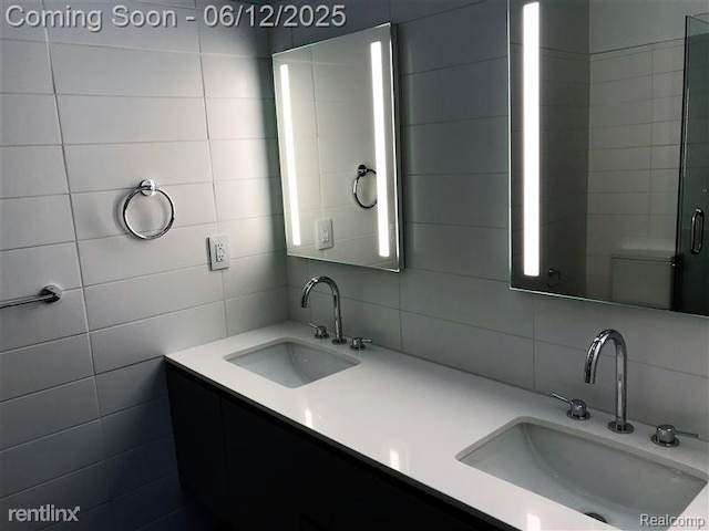 1454 Townsend St Unit 101, Detroit, MI 48214 - bathroom with tile walls, double vanity, and backsplash
