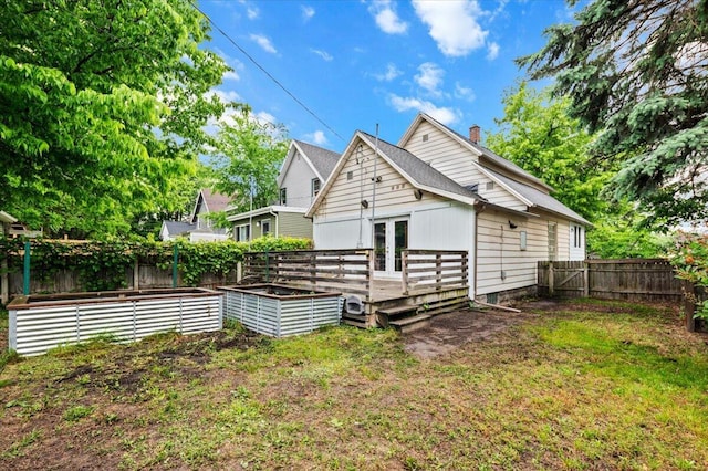 950 Crescent St NE, Grand Rapids, MI 49503 - rear view of property with french doors, a garden, a wooden deck, and a chimney
