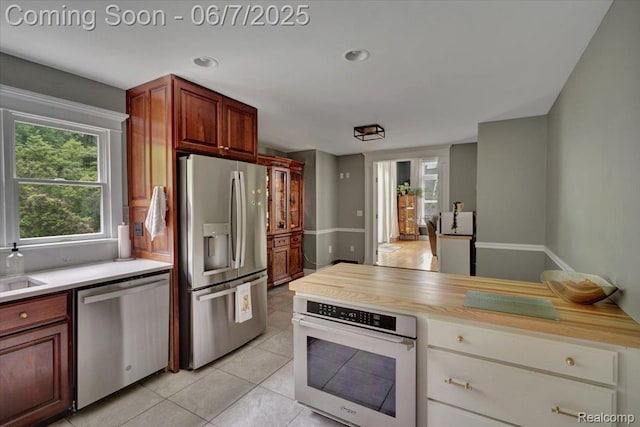 16146 Valcrest Dr, Linden, MI 48451 - kitchen featuring appliances with stainless steel finishes, light countertops, light tile patterned floors, recessed lighting, and a sink