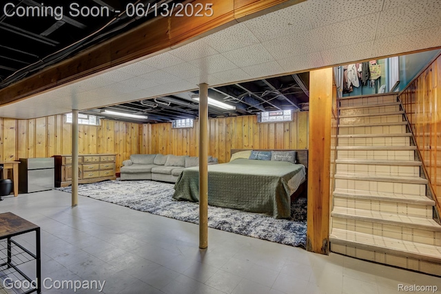 4217 Crooks Rd, Royal Oak, MI 48073 - basement featuring freestanding refrigerator, wood walls, stairway, and tile patterned floors